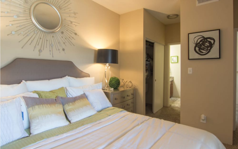 A bedroom with an attached bathroom and walk in closet at Century Lake Apartments in Cincinnati, Ohio