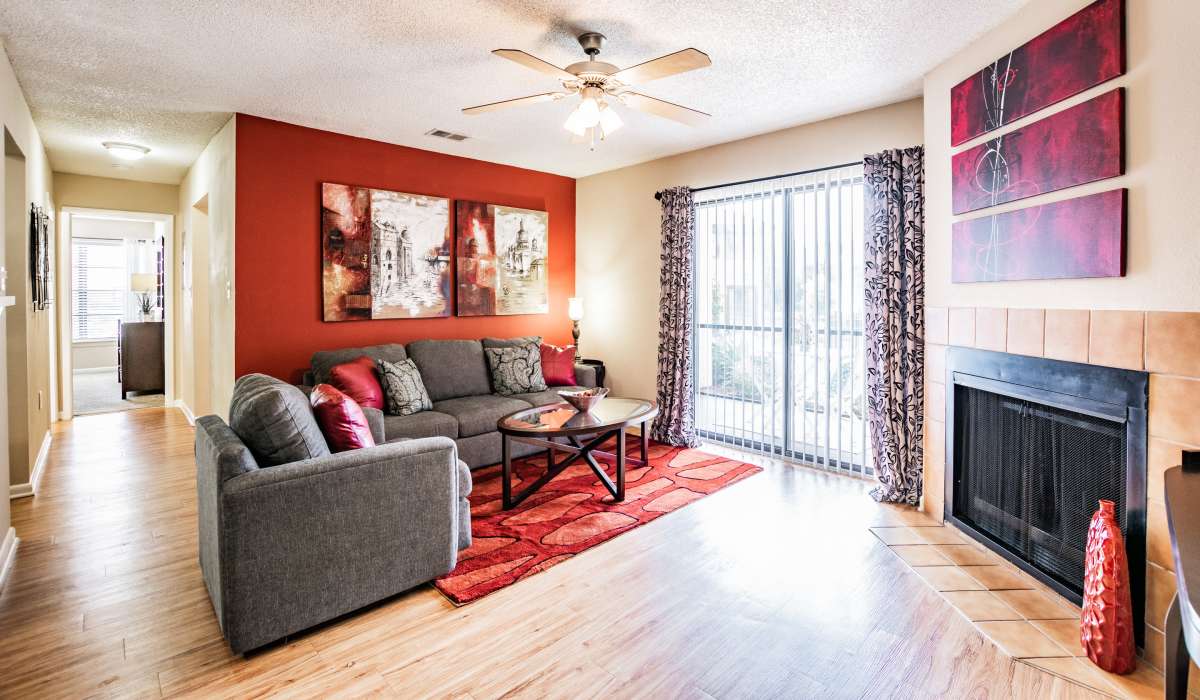 Living room with red accents, balcony access, and fireplace at Waterstone At Carrollwood in Tampa, Florida