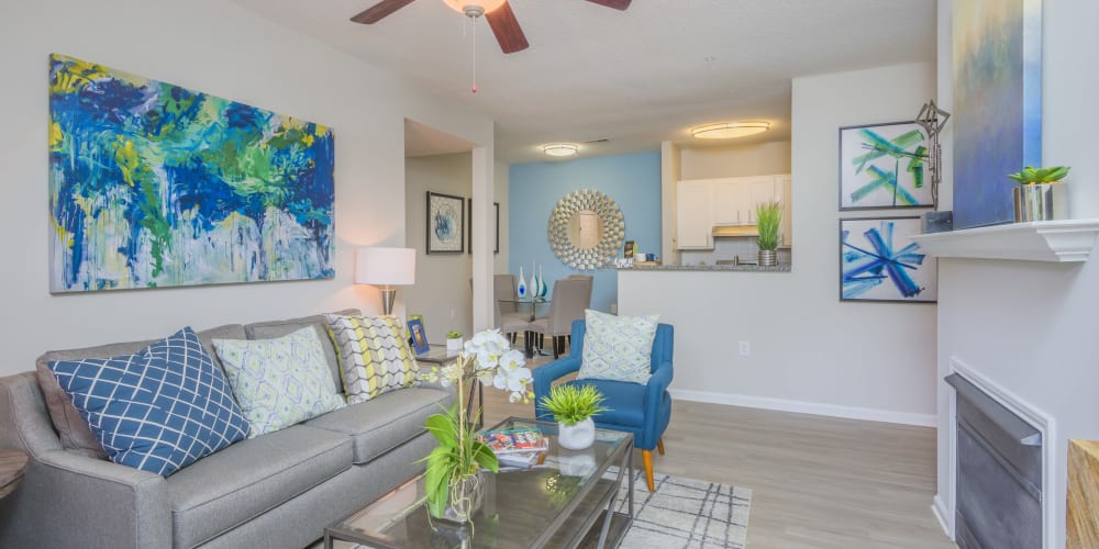 Living room with ceiling fan and wood style flooring at The Mark in Raleigh, North Carolina