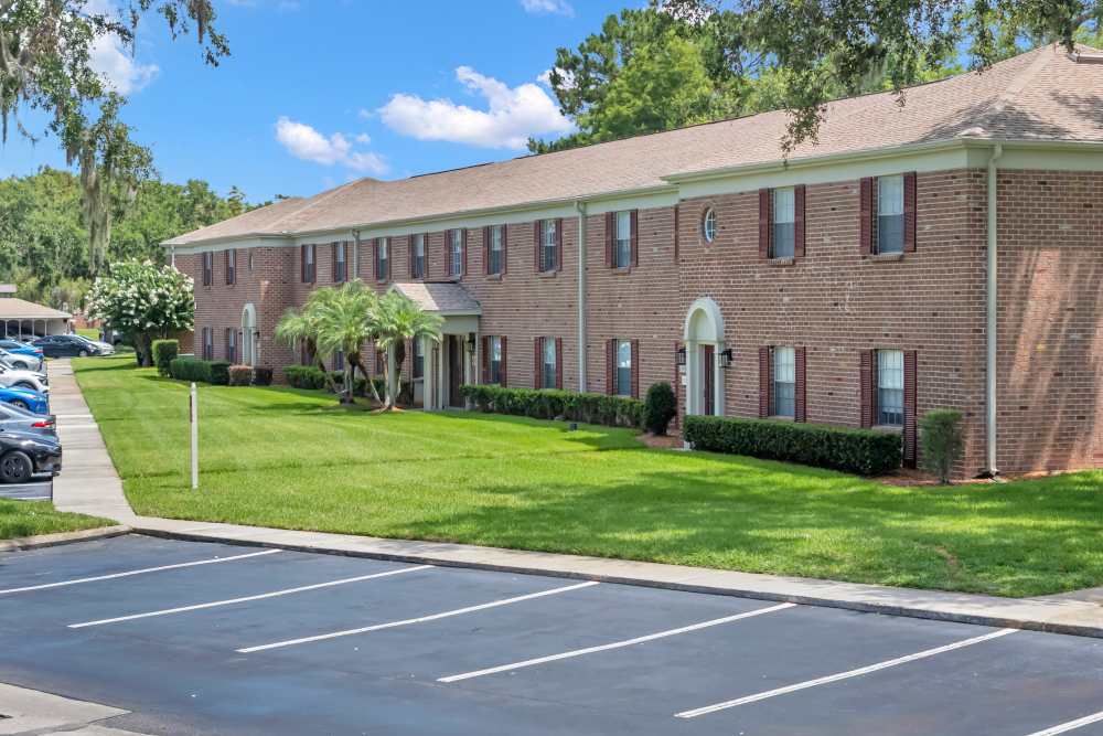 Exterior view of the community with parking area at Lake Carlton Arms in Lutz, Florida