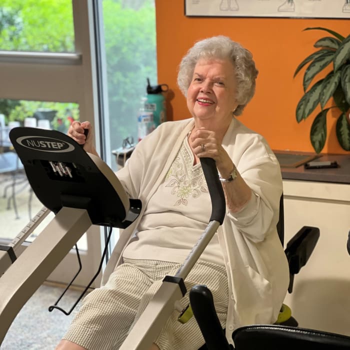 Resident on a stationary bike in the fitness room at Presbyterian Communities of South Carolina in Columbia, South Carolina