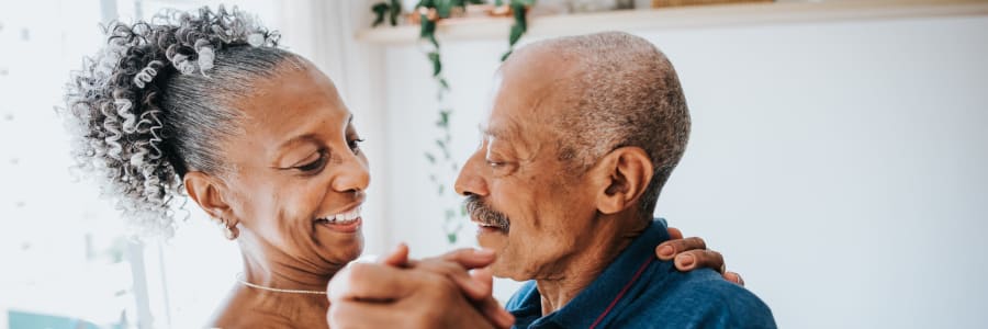 Resident couple dancing in their apartment at a WISH community