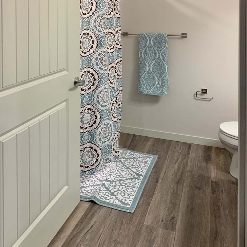 Bathroom with bathtub and wood-style flooring at Depot on Main in Zimmerman, Minnesota