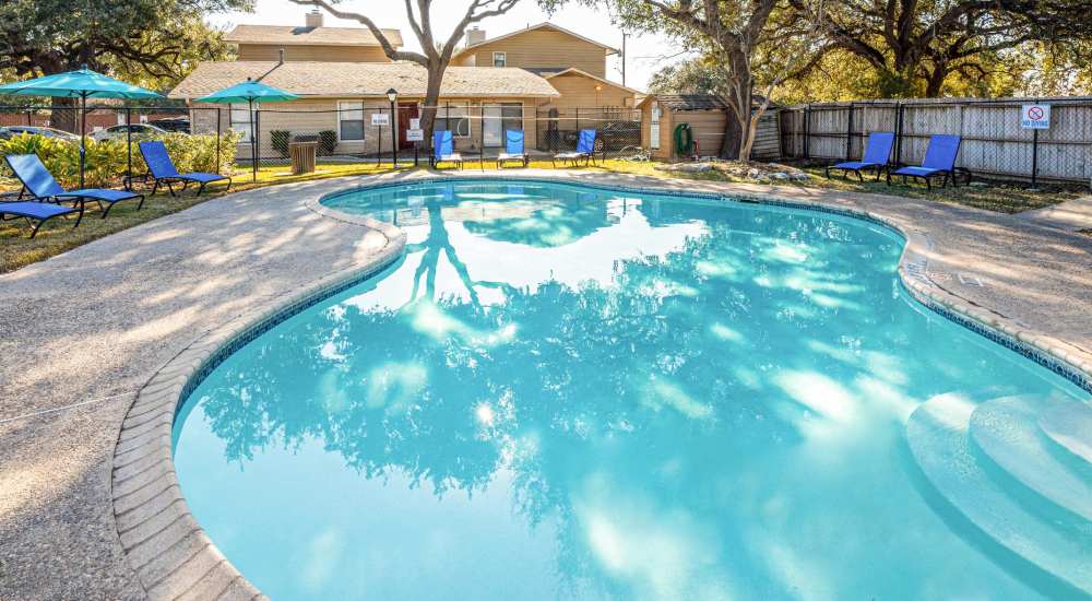 Relax near swimming pool at The Camaron Townhomes & Flats in San Antonio, Texas