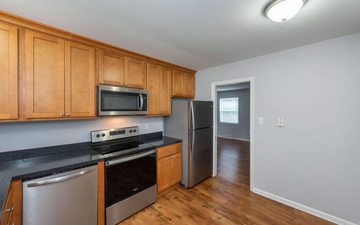 Modern kitchen with stainless-stell appliances and wood cabinet at Signal Point Apartments in Mechanicsville, Virginia