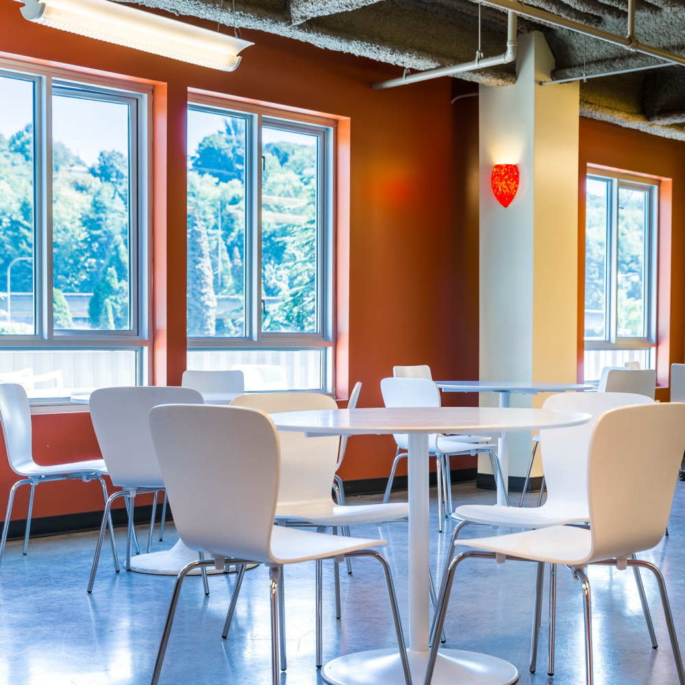 Co-working area with white tables and chairs and large windows at Urban WORKlofts in Seattle, Washington