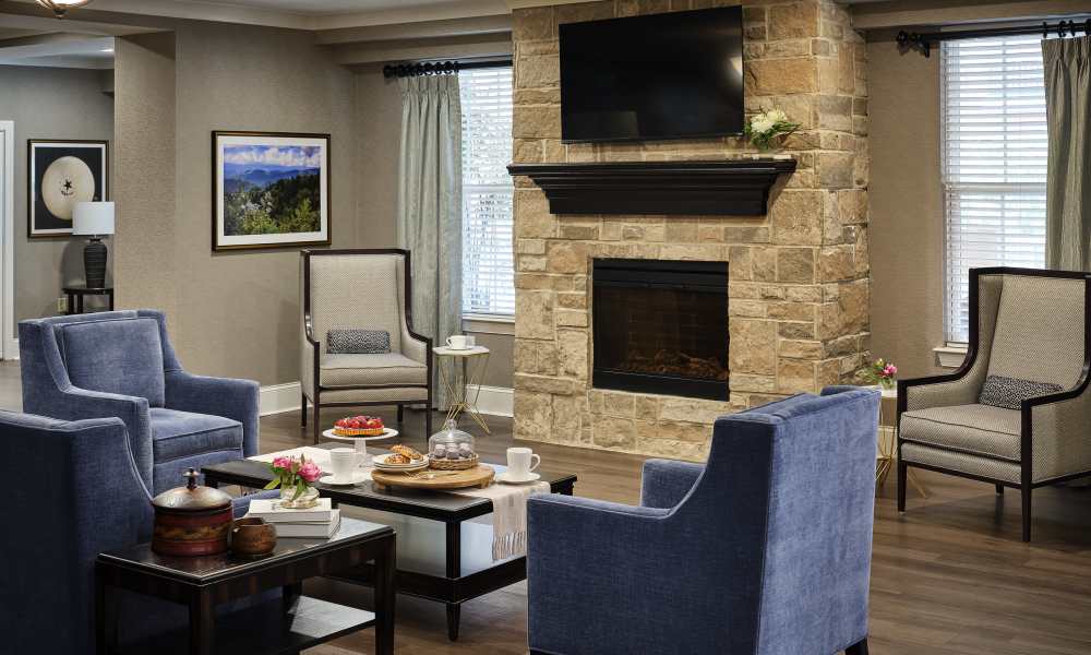 Resident lounge with fireplace and comfortable seating at Waltonwood Cotswold in Charlotte, North Carolina  