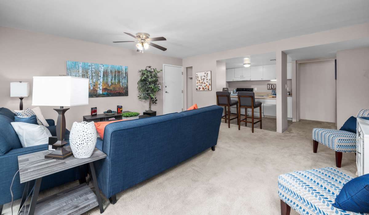 Living room with carpet flooring and blue furniture at West End Terrace Apartments in St. Louis, Missouri