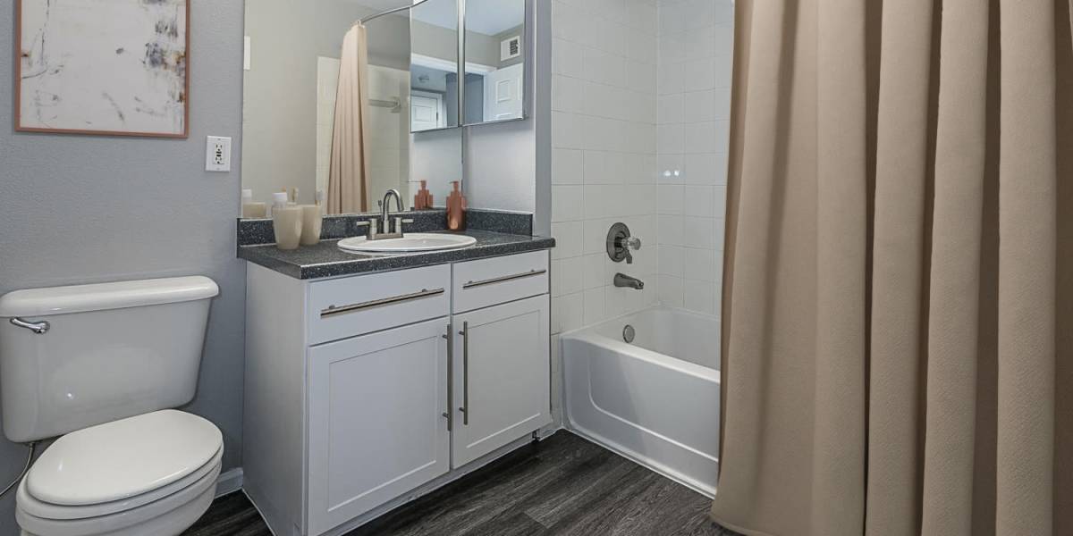 Renovated bathroom with white cabinetry at Tuscany Village Apartments in Ontario, California