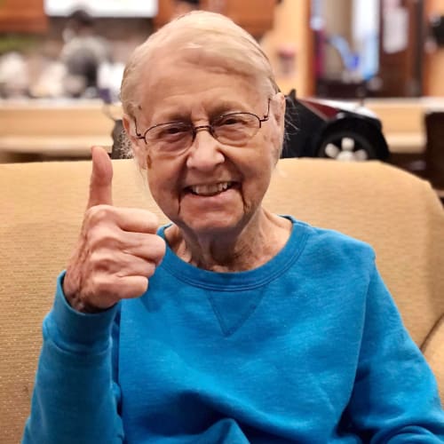 Smiling resident giving a 'thumbs up' at Oxford Glen Memory Care at Carrollton in Carrollton, Texas