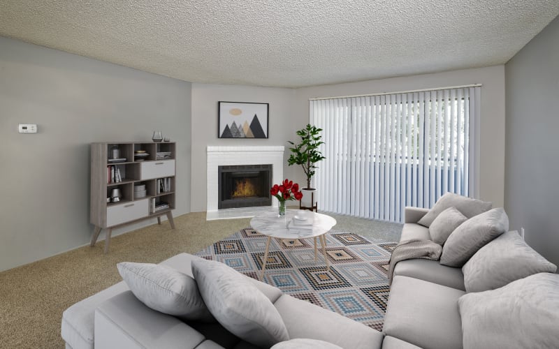 Spacious and bright living room with a fireplace at Alton Green Apartments in Denver, Colorado