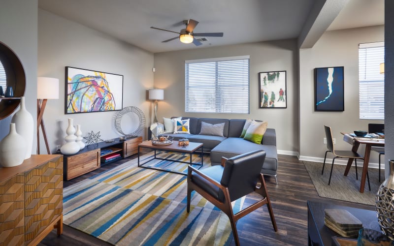 A furnished living room with blue accents at The Rail at Inverness in Englewood, Colorado