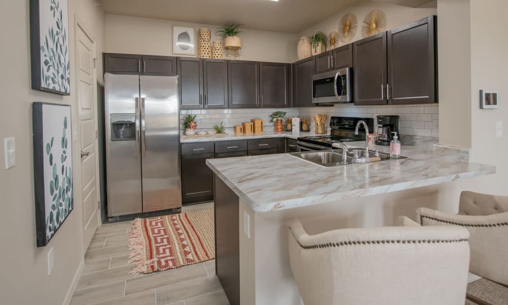 Spacious kitchen with granite countertops and dark cabinetry at Redbud Ranch Apartments in Broken Arrow, Oklahoma