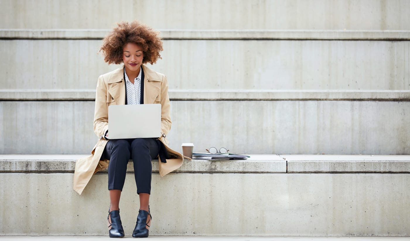 Resident working on her laptop on the steps outside her office near Vue at Laurel Canyon in Valley Village, California