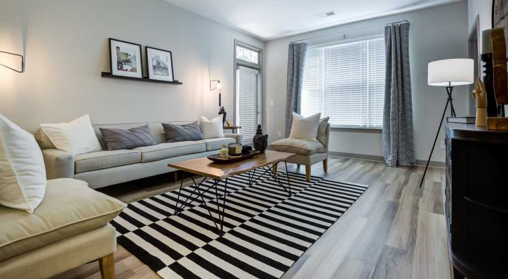 Leather couch and a comfortable chair in a model home's living space at Continuum 115 in Mooresville, North Carolina