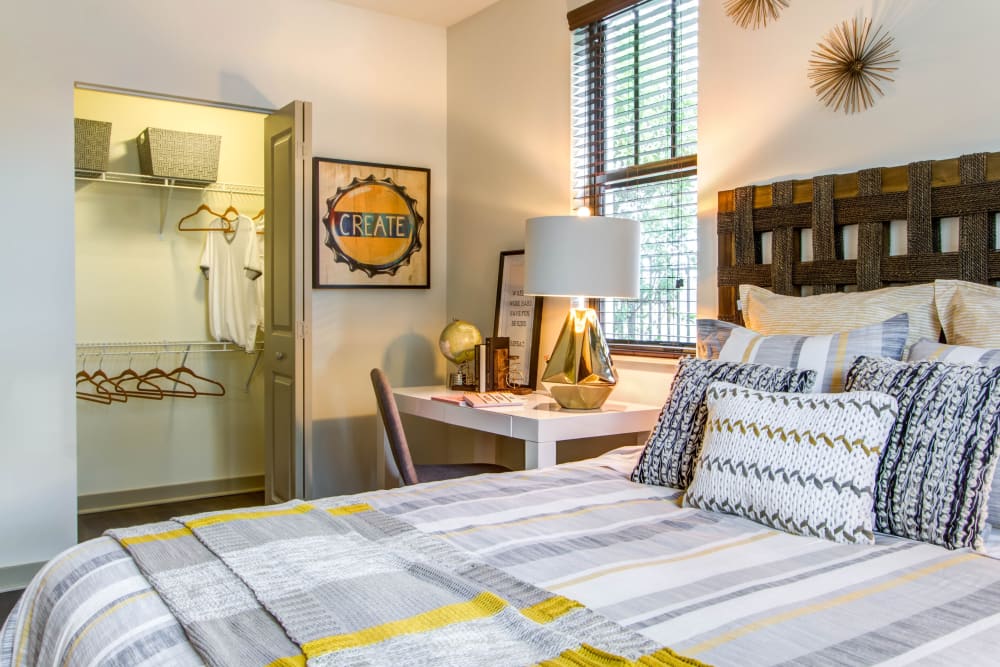 Model bedroom with a desk and a walk-in closet at Luzano in Pompano Beach, Florida