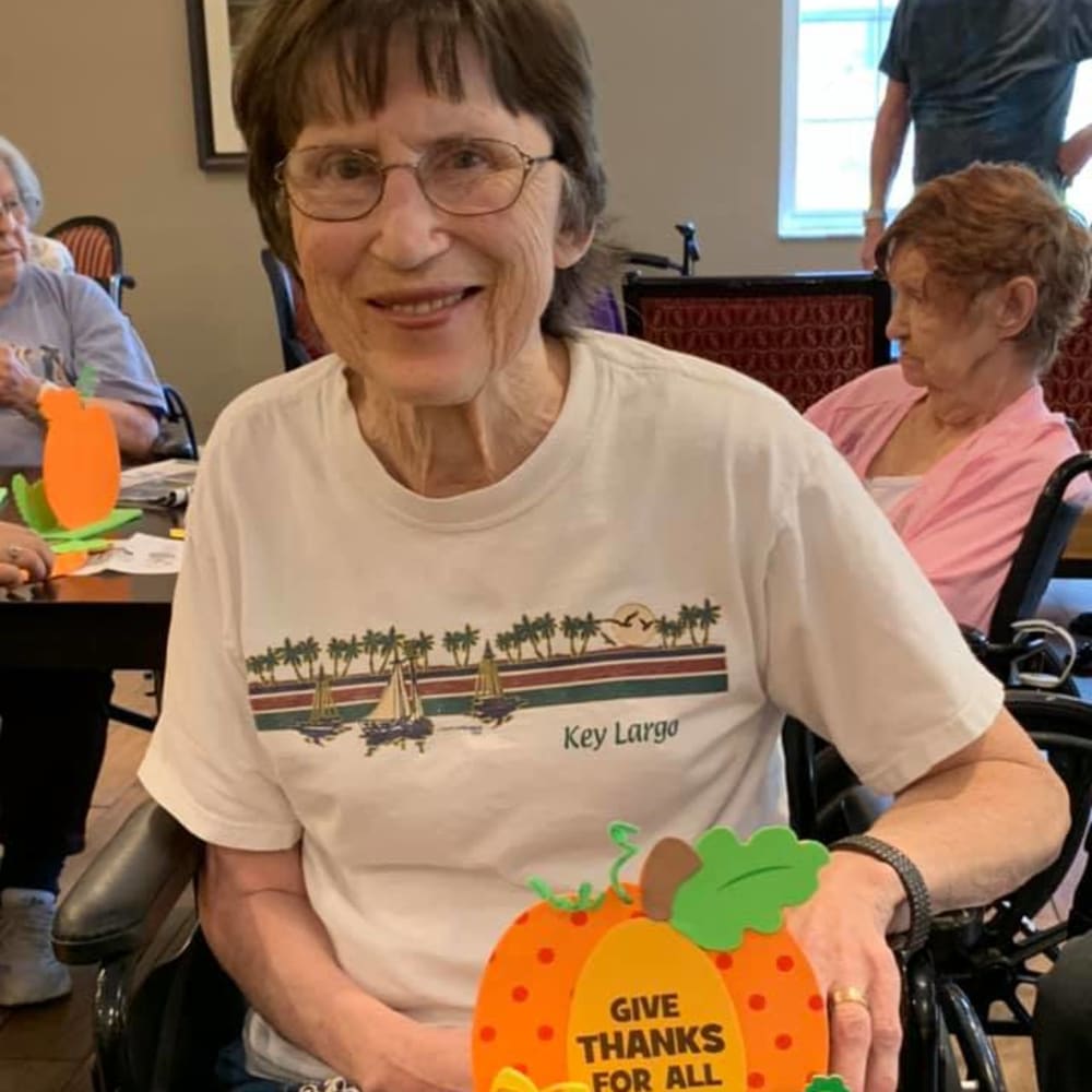 A resident showing off her art project she made at Inspired Living Sun City Center in Sun City Center, Florida