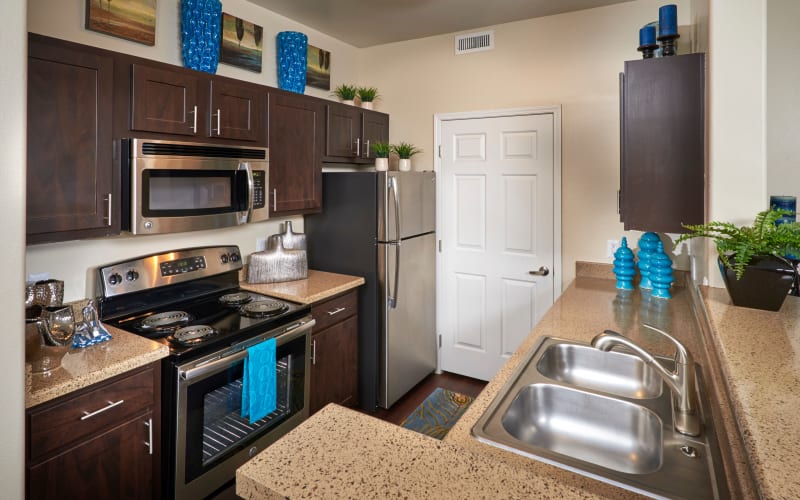Well organized, renovated kitchen with brown cabinets at Promenade at Hunter's Glen Apartments in Thornton, Colorado