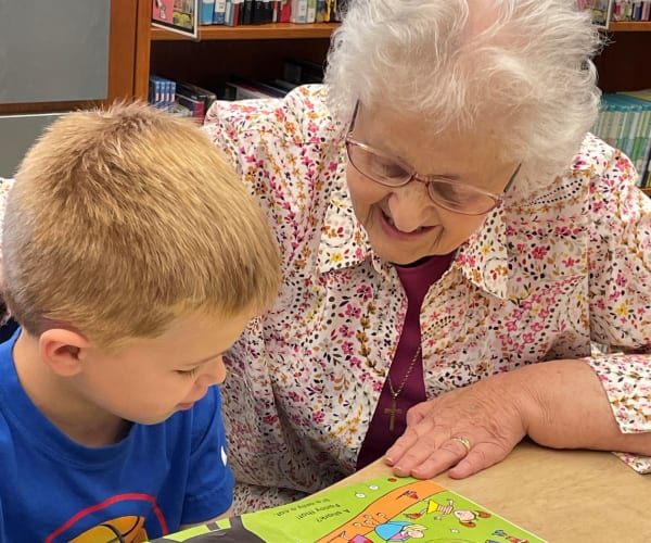 Resident reading a book with a child at The Columbia Presbyterian Community in Lexington, South Carolina