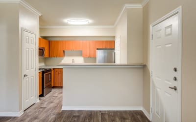 Dining area and modern kitchen with white appliances in model home at The Landing at Mansfield in Mansfield, Texas