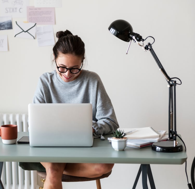 Resident filling out a form on the community's website on her laptop in her home office at Terra Martinez in Martinez, California