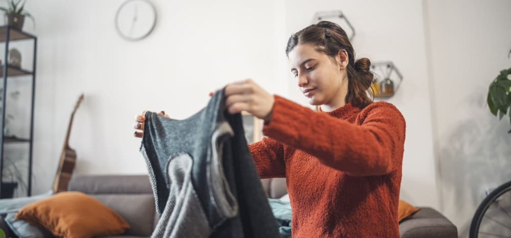 Resident folding a sweater at Cascade Ridge in Tacoma, Washington