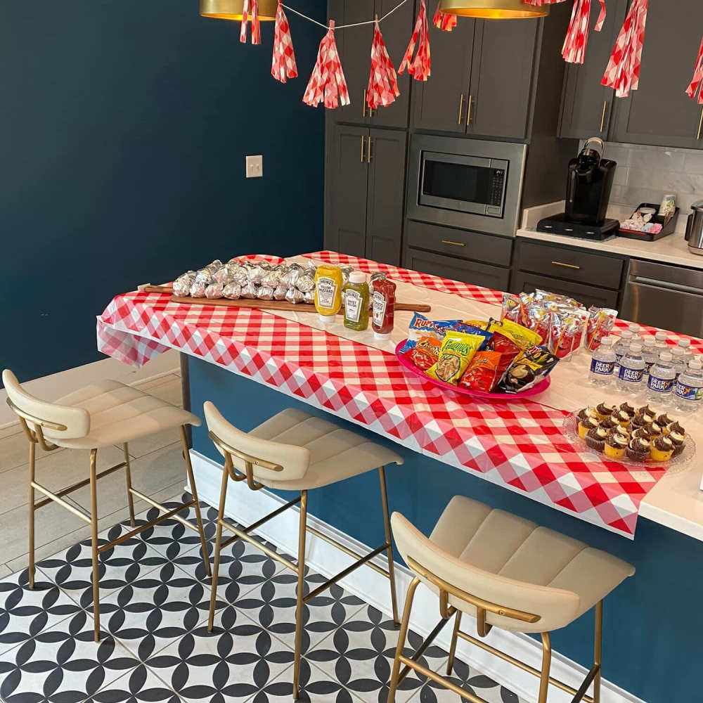 Community event with snacks at kitchen island at The Apartments At Kelton Station in Williamsburg, Virginia