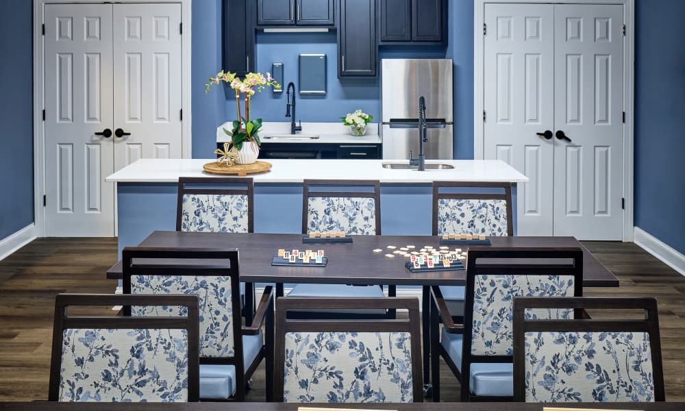 Apartment kitchen with dining table and modern cabinetry at Waltonwood Cotswold in Charlotte, North Carolina  