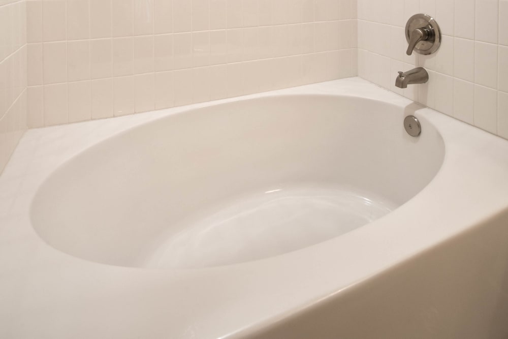 Oval soaking tub in a model home's primary bathroom at Olympus Waterford in Keller, Texas