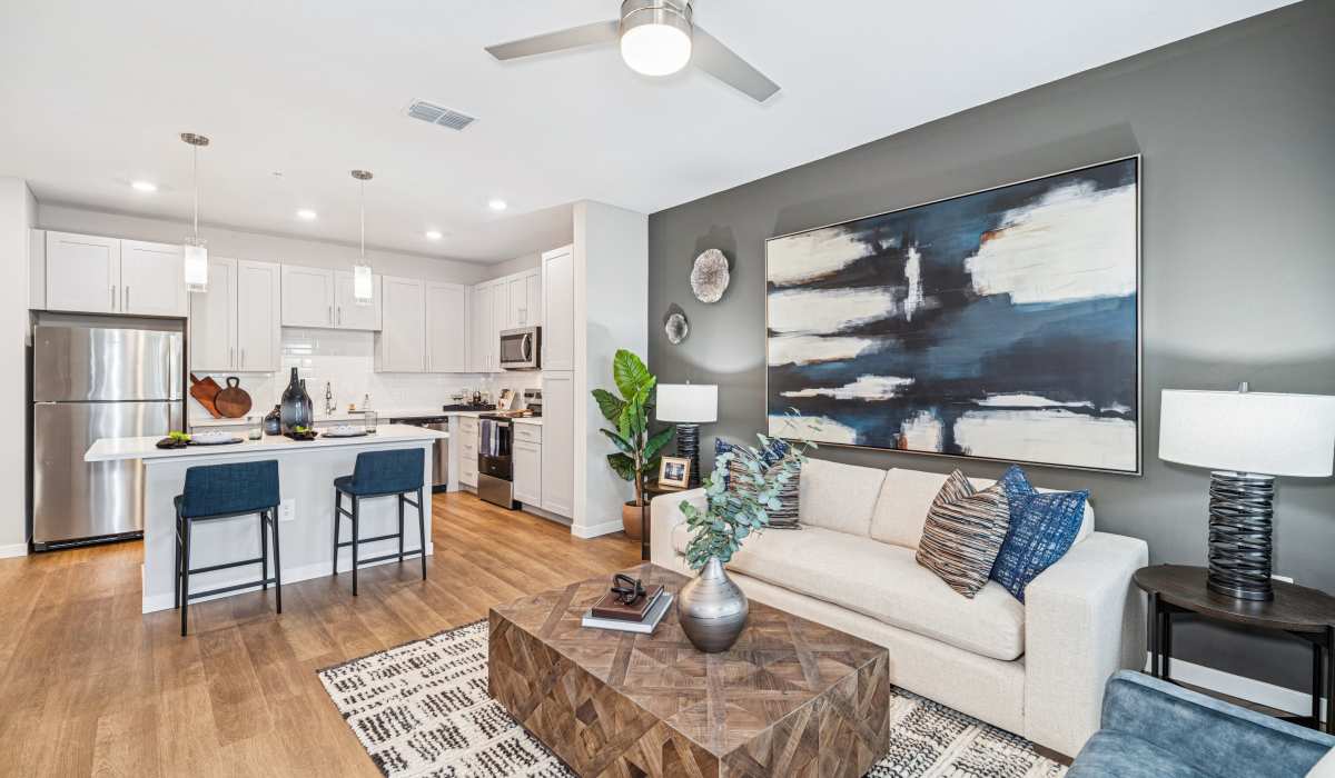 Living area and kitchen with wood-style flooring at Savelle Nona West in Orlando, Florida