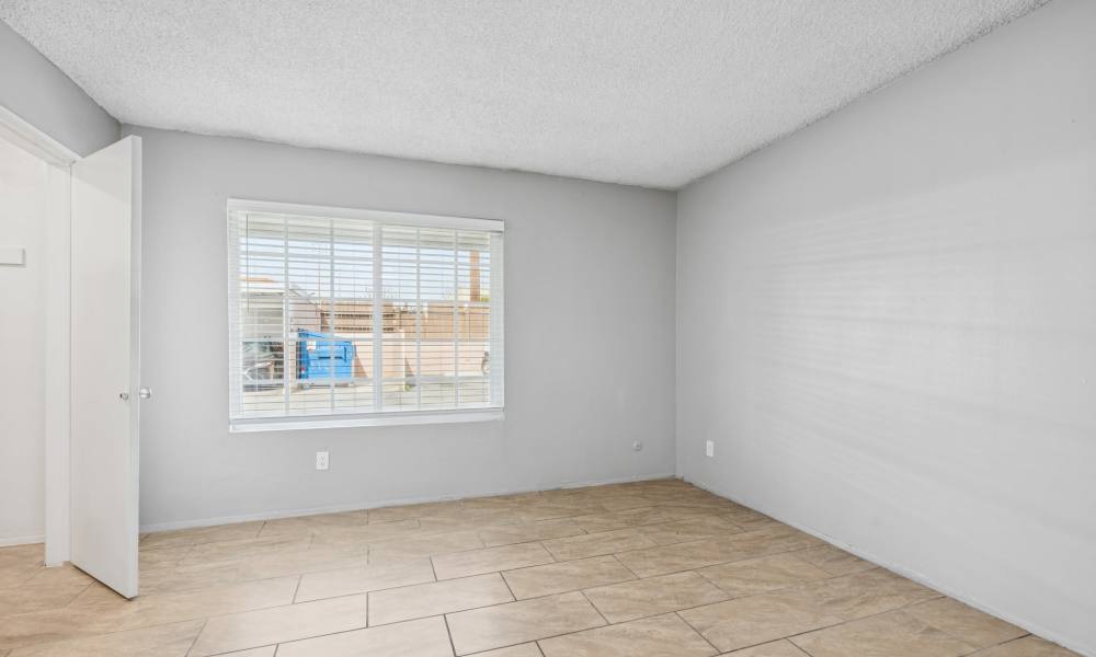 Bedroom with window at Newland Garden Apartments in Garden Grove, California