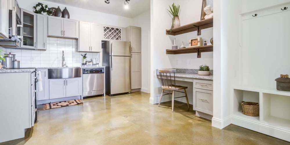 Fully equipped kitchen with granite countertops stainless steel appliances like a refrigerator, stove, and drawer microwave at Magnolia South in Holly Springs, North Carolina 