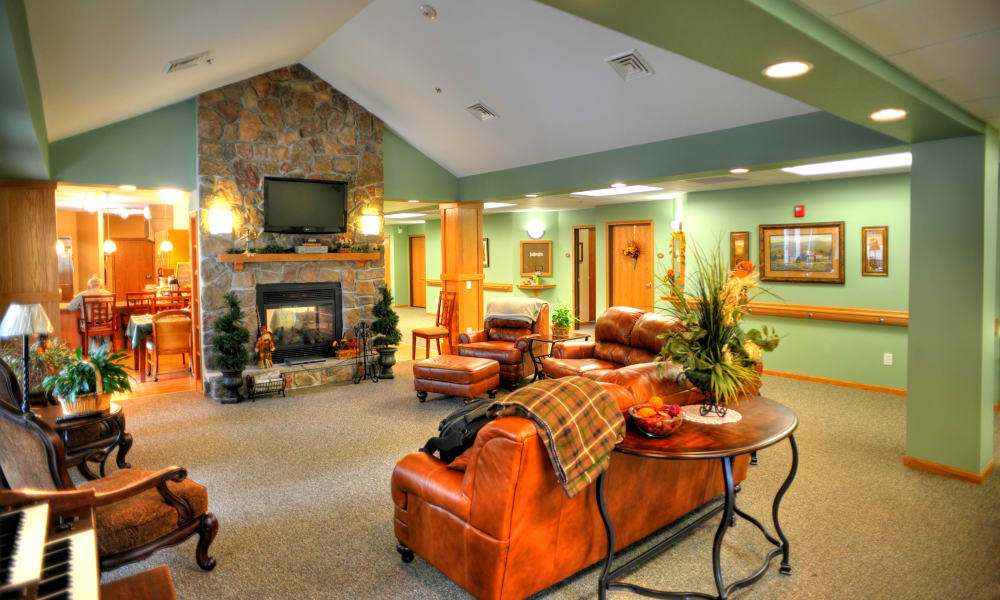 Resident living room area with leather furniture and fireplace at The Residences on Forest Lane in Montello, Wisconsin