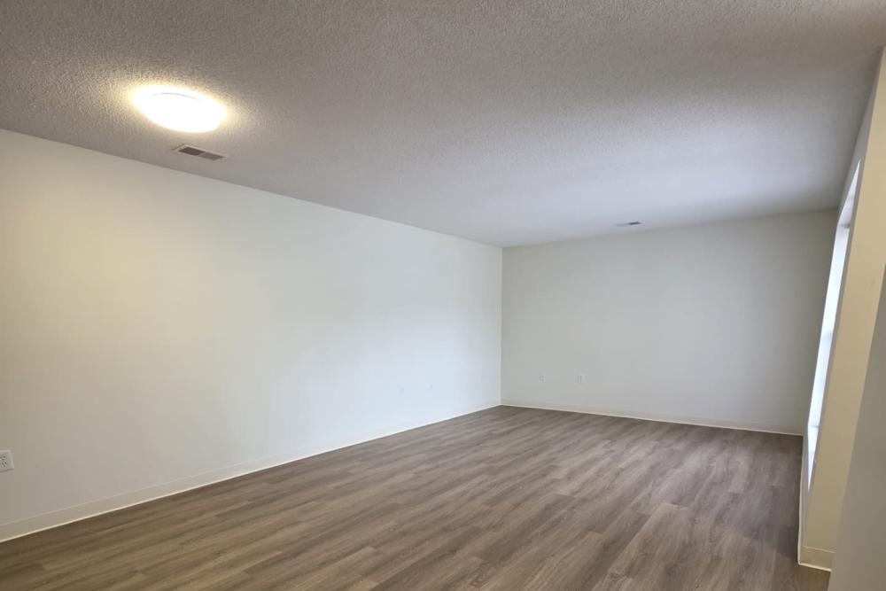 Spacious living area with wood-style flooring at Cottages of Shippensburg in Shippensburg, Pennsylvania