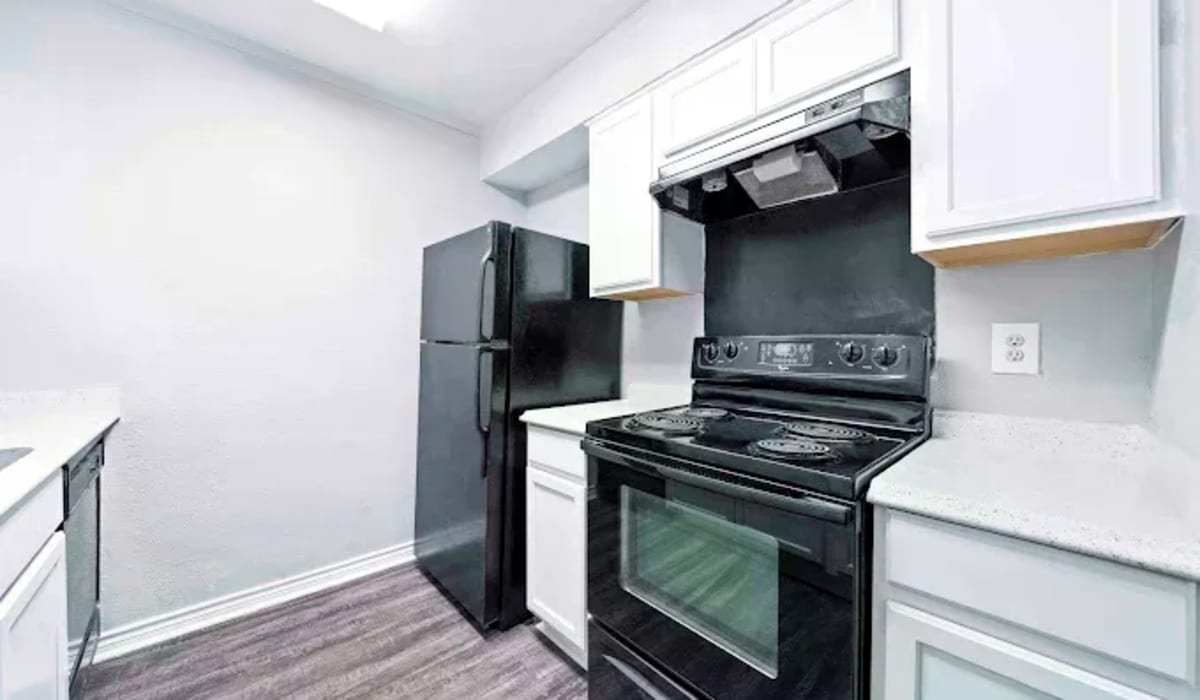 Kitchen with black appliances at Tradewind Apartments in Mesquite,Texas