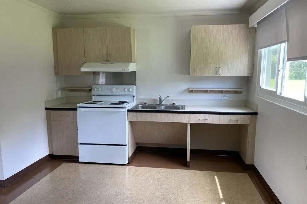 Kitchen with wood cabinet and white range at Pineda Village in Cocoa, Florida