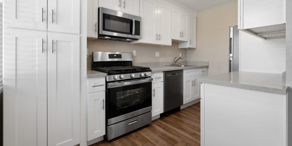 Fully-equipped kitchen with stove and microwave at Bon Aire Apartments in Castro Valley, California