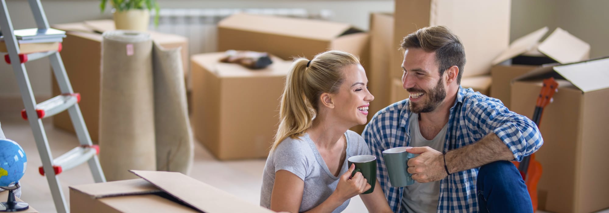 Couple Smiling Amidst Moving Boxes
