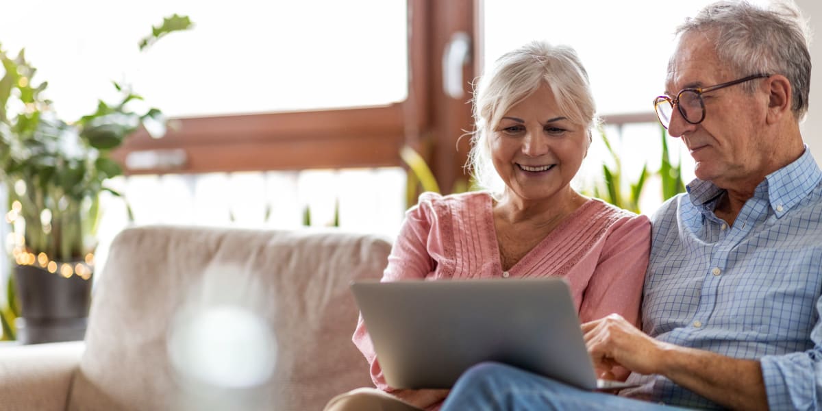 Residents working on laptop together on couch at The Links at Plum Creek in Castle Rock, Colorado
