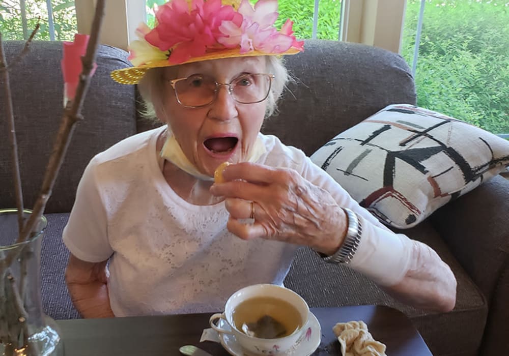 Cheerful resident enjoying tea and cookies at The Residences on Forest Lane in Montello, Wisconsin