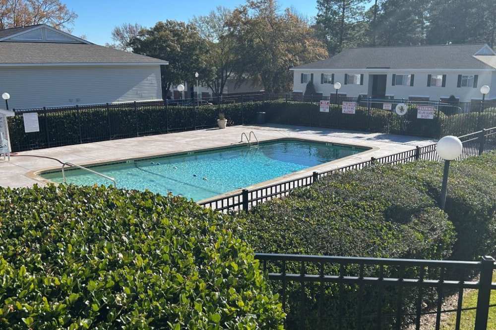 Charming sparkling water pool surrounded by lush landscaping at High Point Crossing Apartments in Augusta, Georgia.