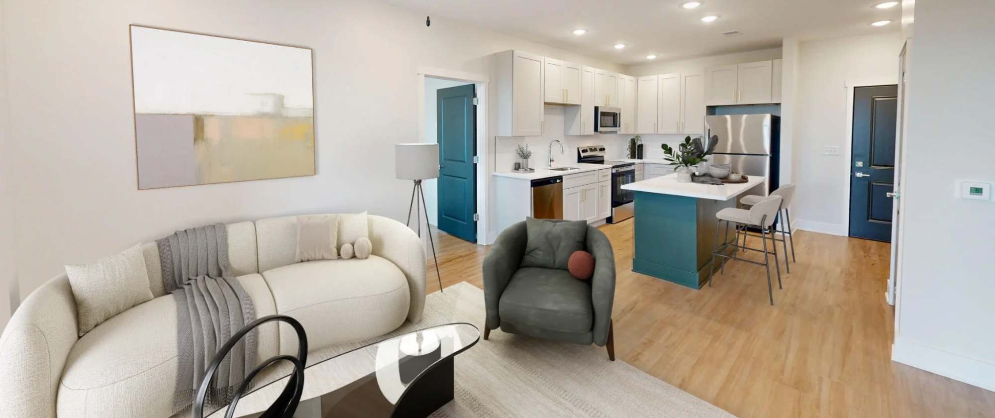 Staged living area of the Deuce floor plan at Factory 52, featuring a modern kitchen with white cabinetry, an island, and a furnished open-concept layout.