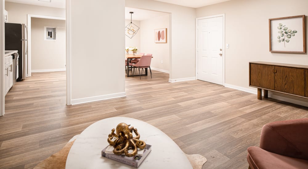 Spacious living room with wood flooring in a model home at Bradford Place Apartments in Byram, Mississippi