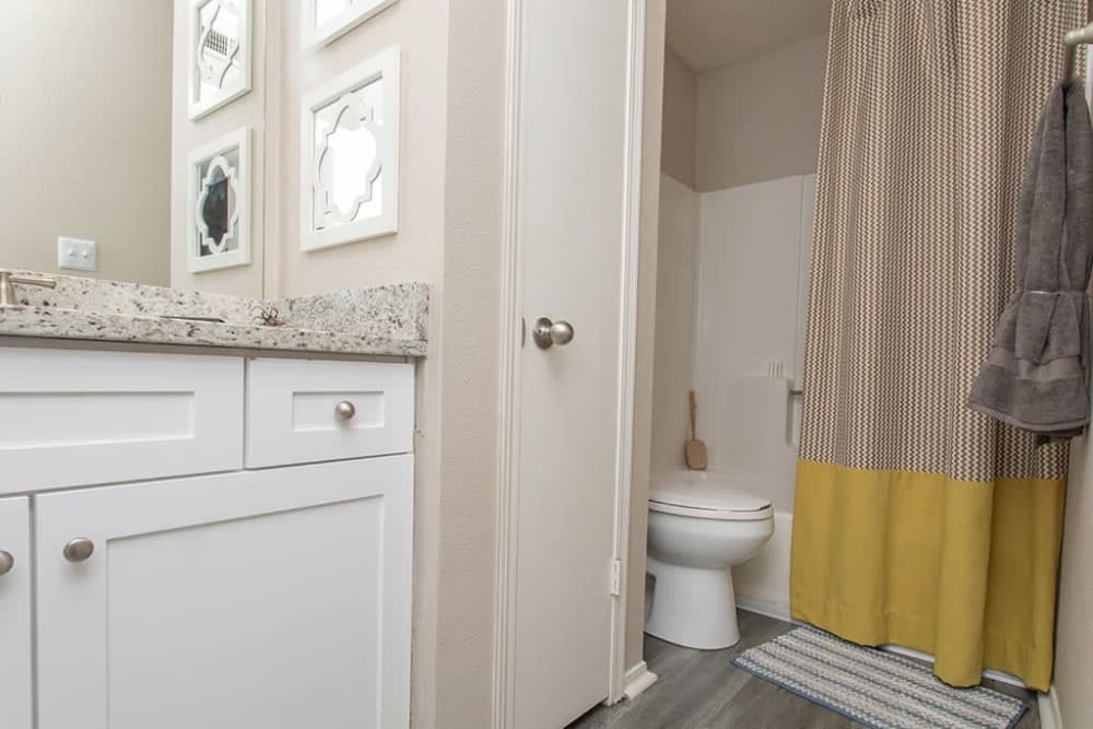Bathroom with linen closet and tub/shower combination at Castlegate Collier Hills in Atlanta, Georgia