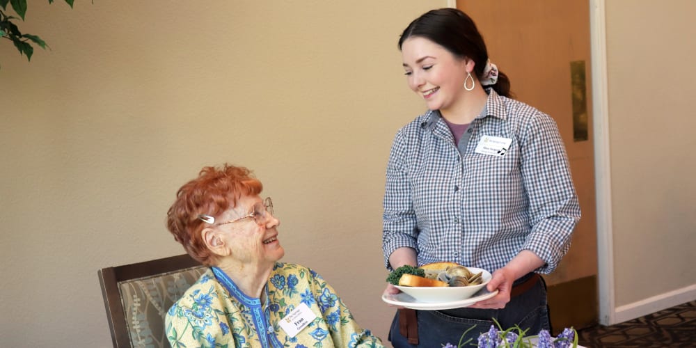 Resident being served dinner in dining room at The Springs at Anna Maria in Medford, Oregon