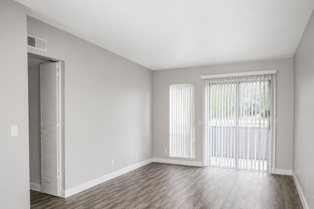 Living room with wood floors, gray walls, and sliding glass doors to patio at The Everette in Rocklin, California