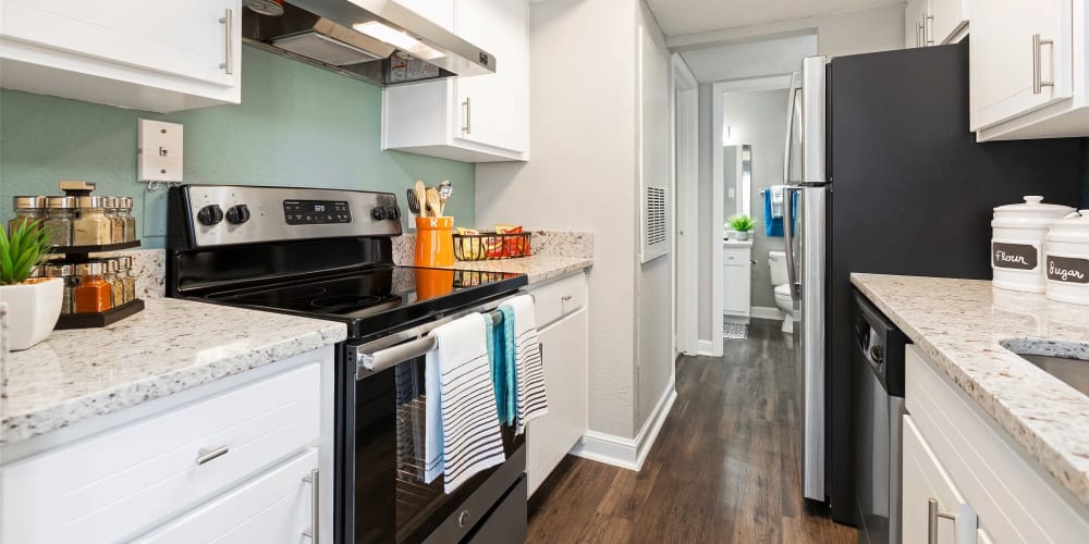 Modern kitchen with wood-style floors at Lago Paradiso at the Hammocks in Miami, Florida