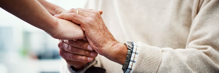 Resident holding hands with a younger family member at Montello Care Center in Montello, Wisconsin