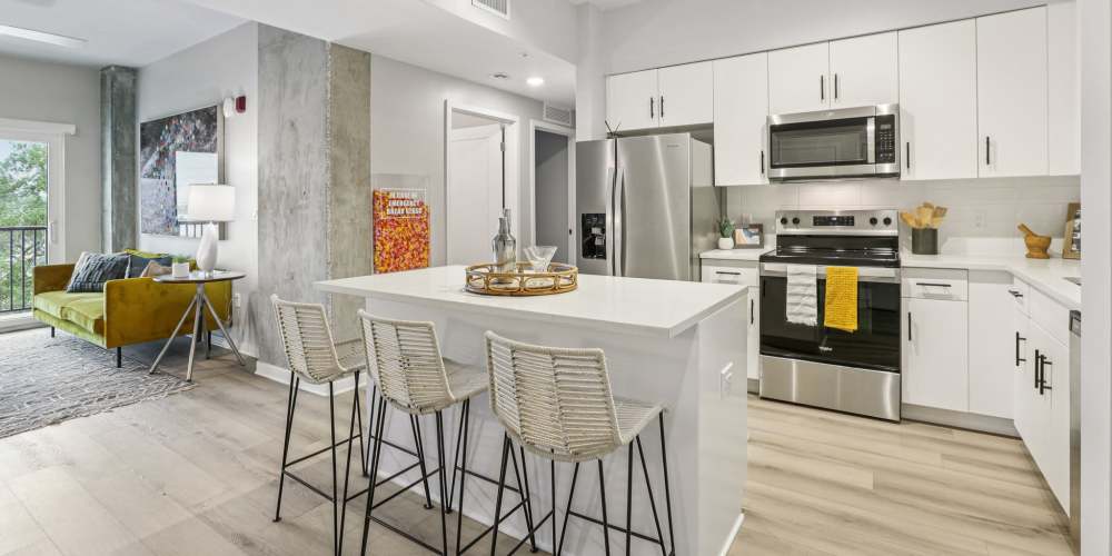View of the kitchen and living room with wood-style flooring at The Breeze in Winter Haven, Florida  