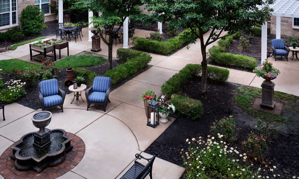 Landscaped courtyard with fountain and outdoor seating at Waltonwood Cotswold in Charlotte, North Carolina  